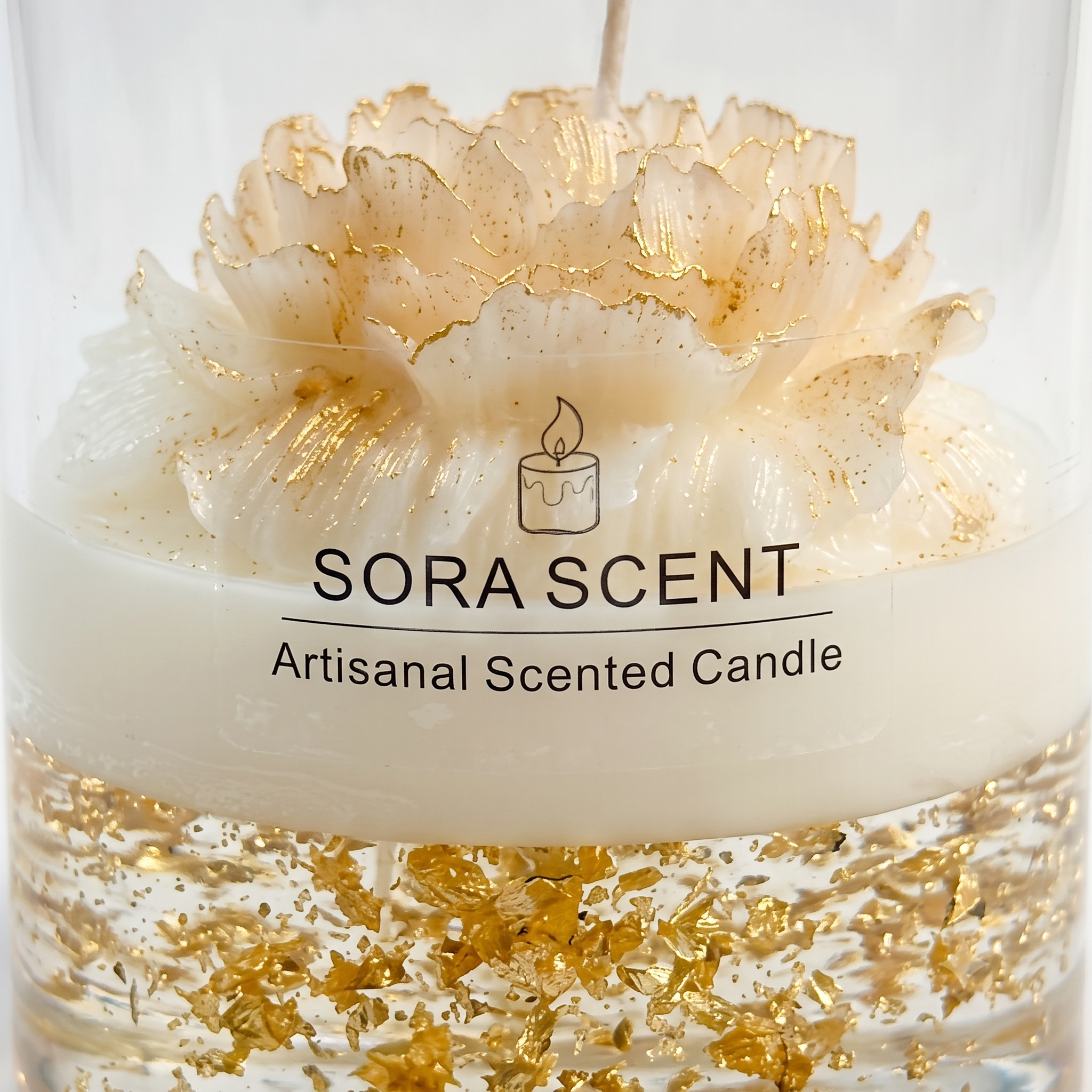 Macro close-up of SORA SCENT's Golden Peony Candle, highlighting the sparkling gold leaf flakes inside the gel layer and the gold-dusted edges of the hand-sculpted wax flower petals.