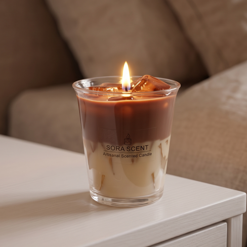 A lit Iced Vanilla Oat Latte Candle by SORA SCENT burning softly, featuring a warm flickering flame illuminating the translucent espresso layer and casting a cozy glow over the room.