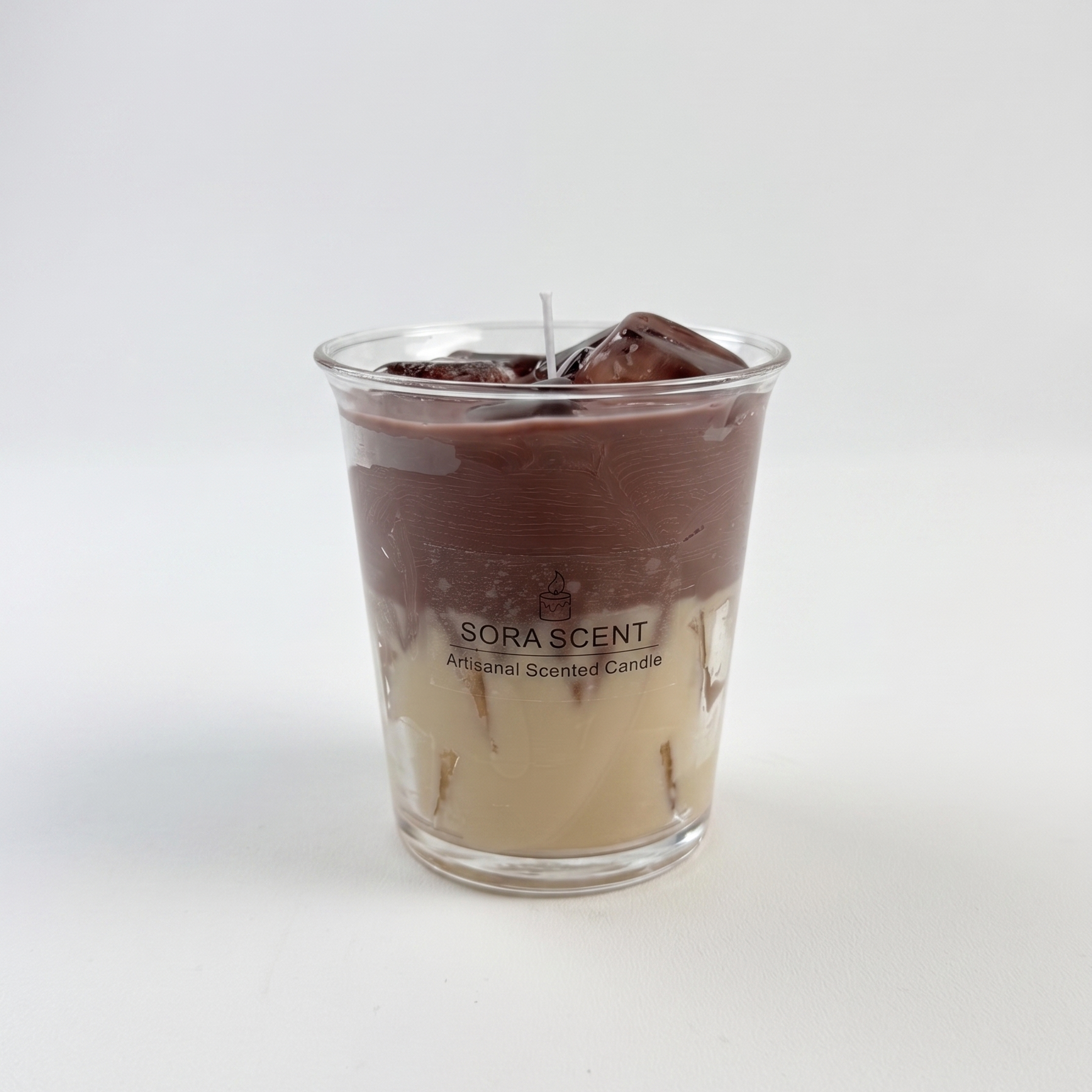 SORA SCENT Iced Vanilla Oat Latte Candle on a clean background, showcasing its creamy white oat milk base, dark espresso top layer, and glistening wax ice cubes in a clear glass.