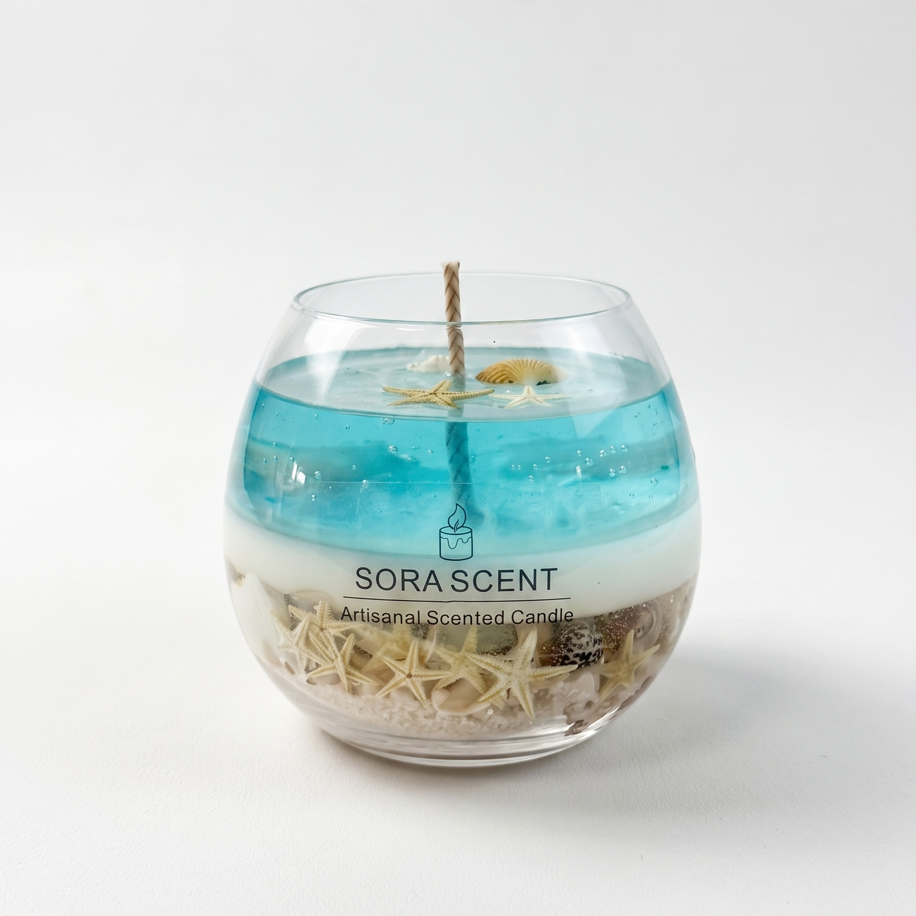 SORA SCENT Coastal Lagoon Sea Salt Candle on a clean background, showcasing its round glass bowl, real sand and starfish base, white sea foam layer, and translucent blue bubbling gel wax.