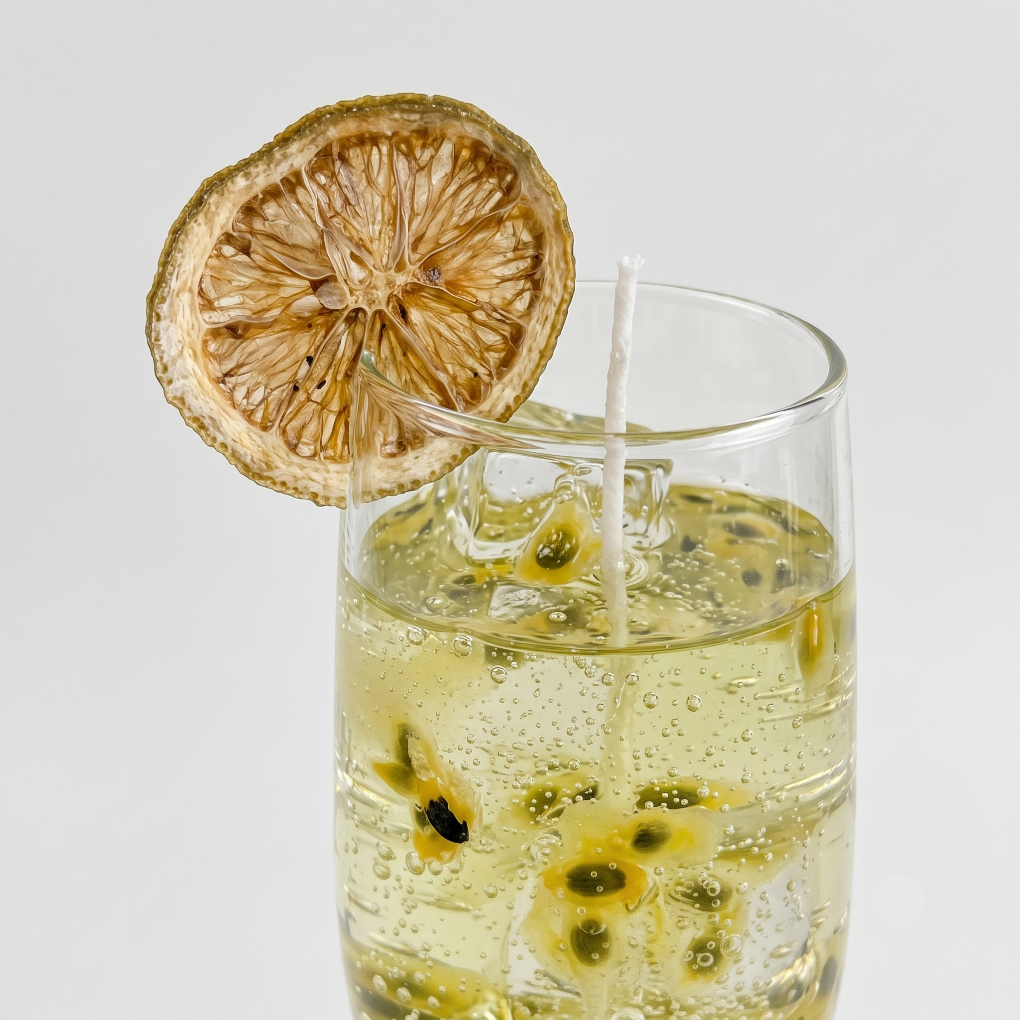 Macro close-up of SORA SCENT's Malibu Sunshine Spritz Candle, showcasing intricate details of realistic wax ice cubes, delicate bubbles, and suspended black and yellow passion fruit seeds inside the high-clarity translucent gel wax.