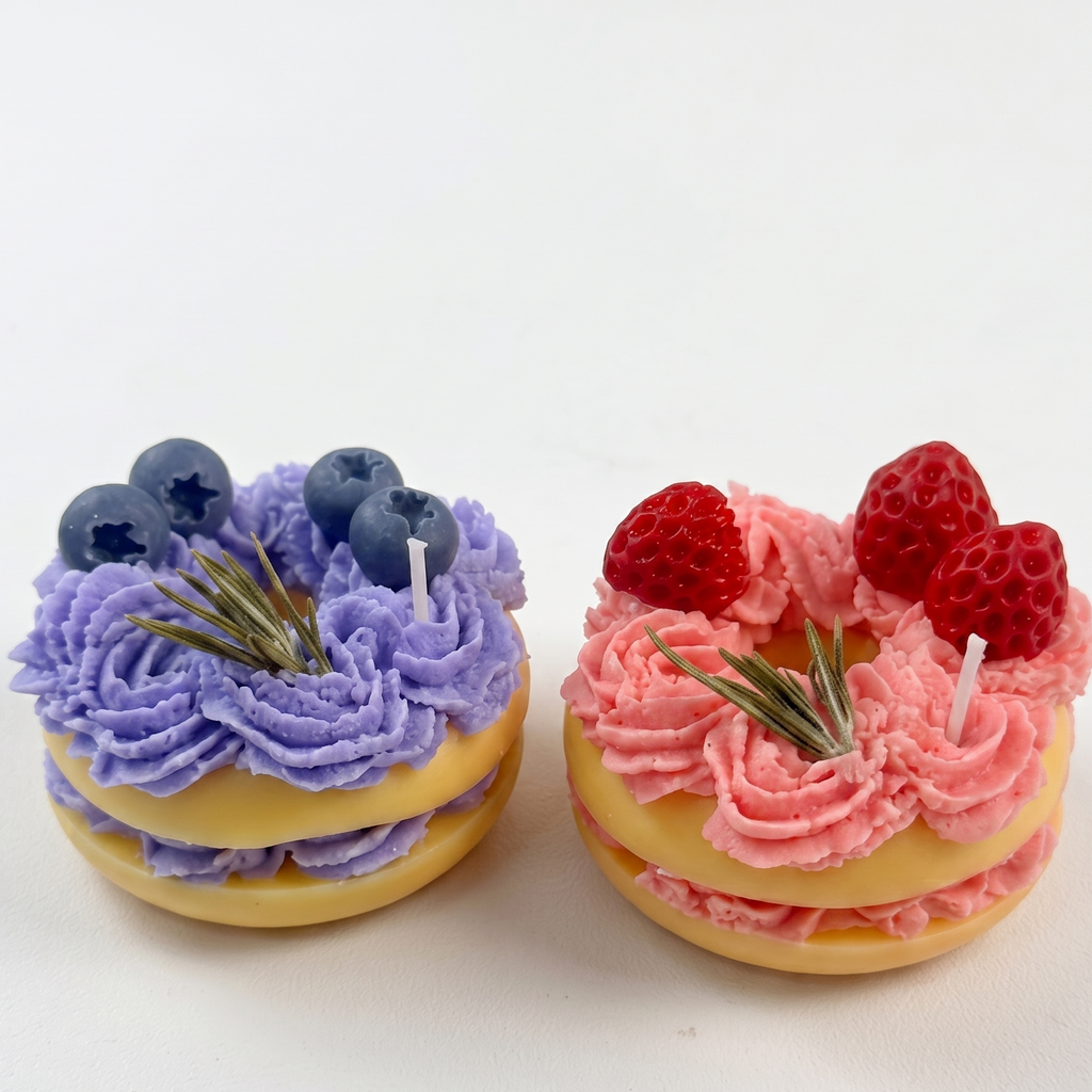 sora-scent-mini-berry-macaron-candles-white-background.jpg` | SORA SCENT Mini Lavender and Strawberry Macaron Candles on a clean background, showcasing their golden macaron bases, piped soy whipped cream, and realistic blueberries and raspberries.